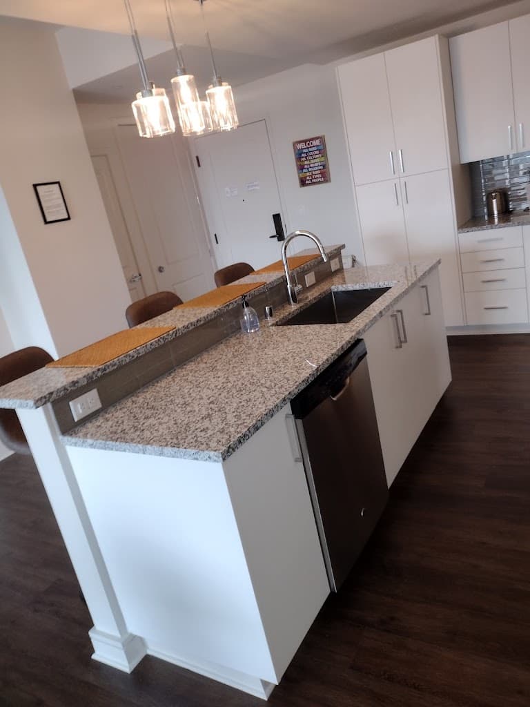 Bright, tidy open-concept kitchen with granite countertop and bar seating